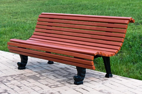 stock image Brown bench against green lawn