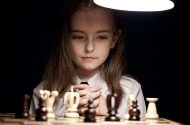 Girl playing chess under lamp clipart