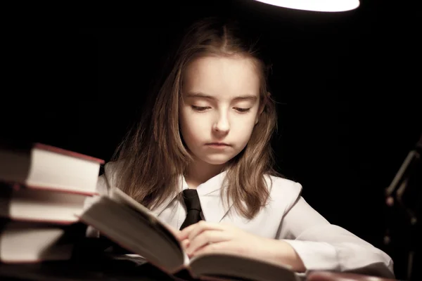 Girl reading book under lamp — Stock Photo, Image