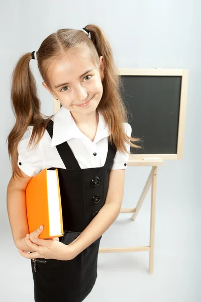 Escola menina com livro amarelo — Fotografia de Stock