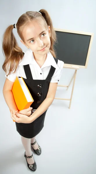 School meisje met gele boek — Stockfoto