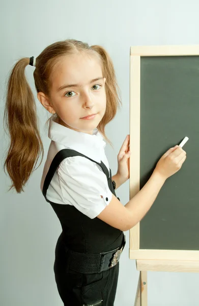 School girl near blank blackboard. Ready for writing. — Stock Photo, Image