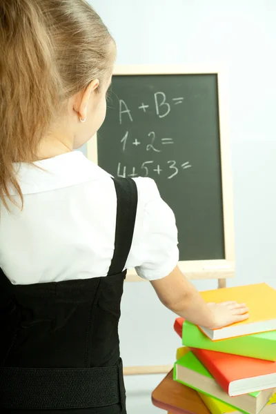 School girl view on the blackboard. Back view. — Stock Photo, Image