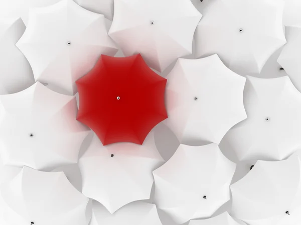 stock image One unique red umbrella, among other white