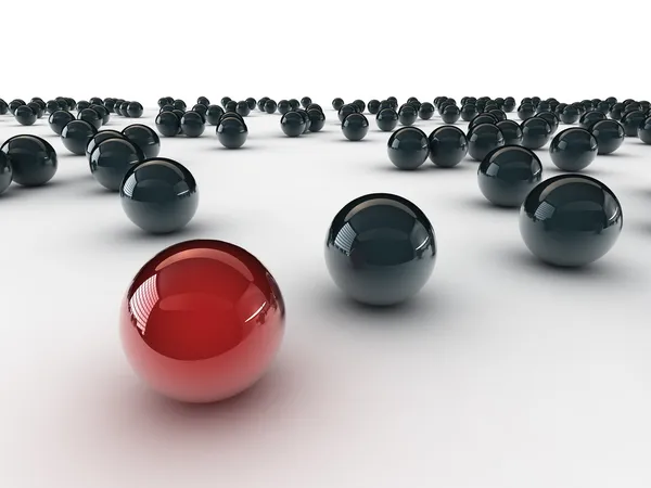 En unik röd boll, bland andra svart — Stockfoto