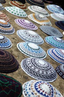 A colorful collection of yarmulkes at Jerusalem market - traditi clipart