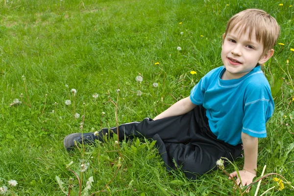 Kleine jongen opleggen op het gras — Stockfoto