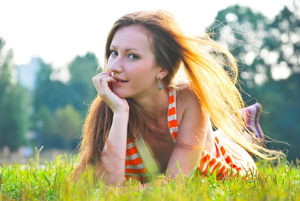 Красивая женщина, лежащая на траве — стоковое фото