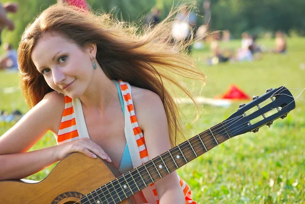Молодая женщина с гитарой — стоковое фото