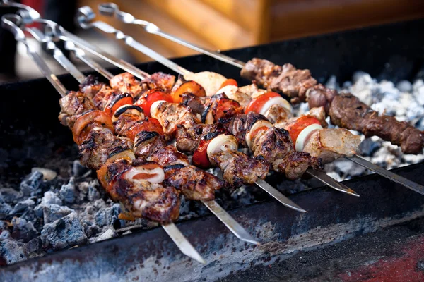 As partes suculentas de carne com o molho preparam-se no fogo (prato de carne shish). — Fotografia de Stock