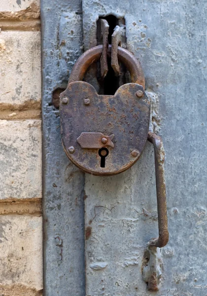 Roestige hangslot op een oude metalen deur — Stockfoto