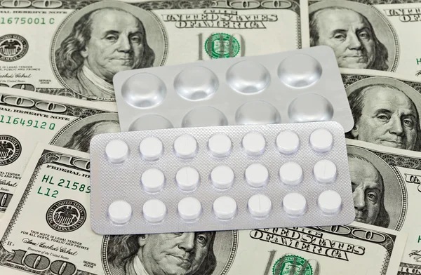 Kosztowne leki codziennie na tle pieniędzy — Zdjęcie stockowe