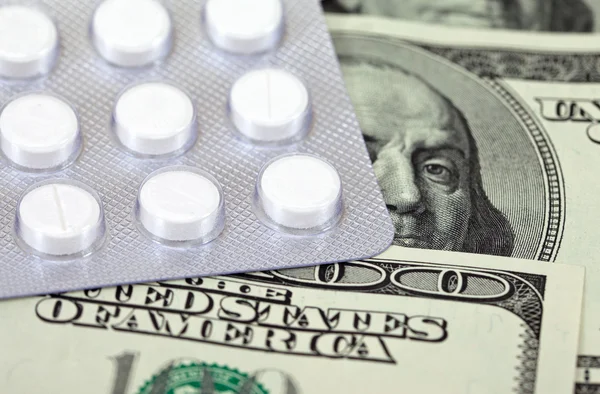 Kosztowne leki codziennie na tle pieniędzy — Zdjęcie stockowe
