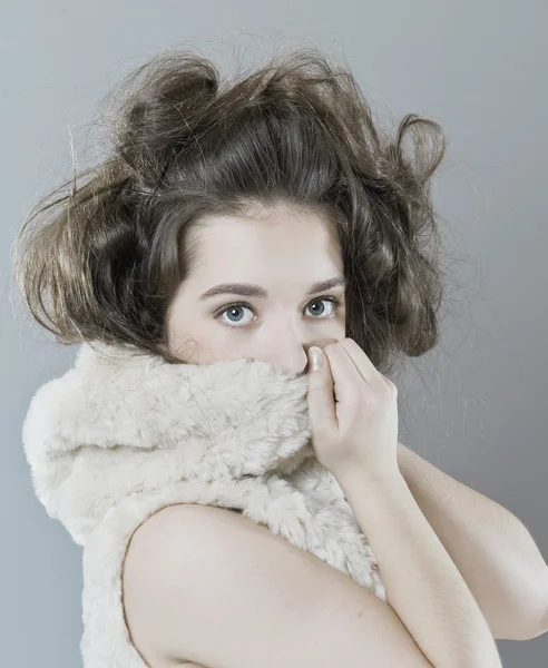 stock image Young girl hiding behind a fur hood.