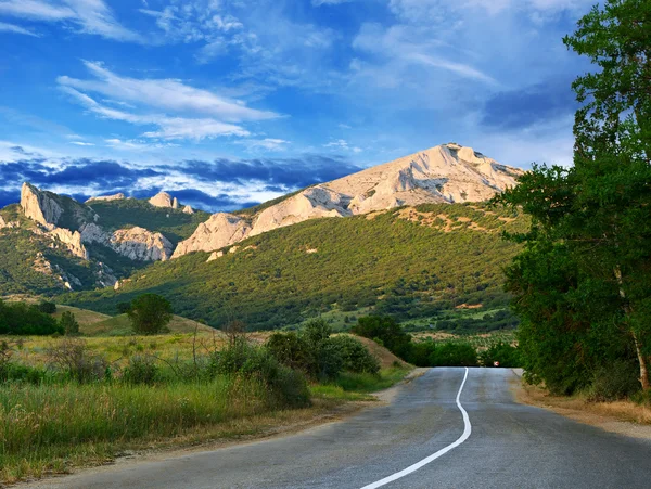 Carretera, montañas y cielo azul — Foto de Stock