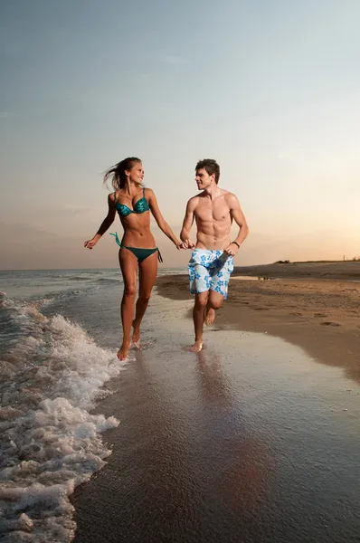 Erkek ve kız plajda çalışan — Stok fotoğraf