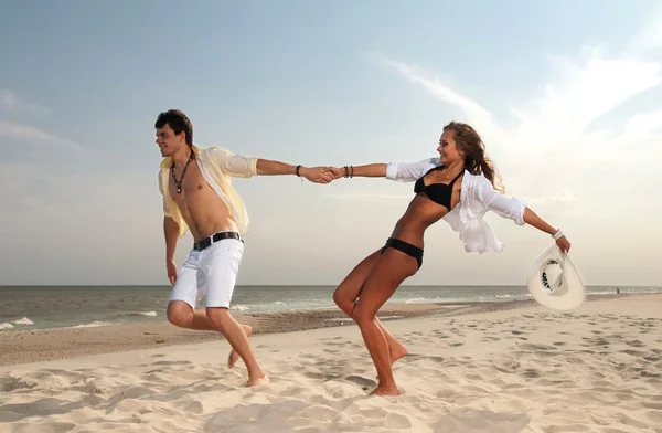 Junge und Mädchen rennen am Strand — Stockfoto