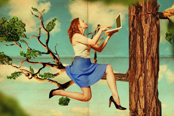Bella donna su albero con computer portatile — Foto Stock
