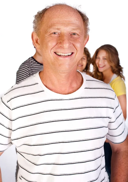 Knappe oude man in focus met familie in de achtergrond — Stockfoto