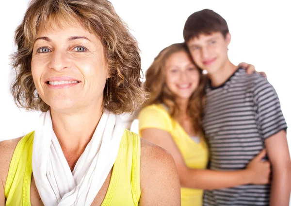 Old lady in focus while mother hugs her son in the background — Stock Photo, Image