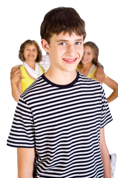 Улыбающийся молодой парень в фокусе с семьей на заднем плане — стоковое фото
