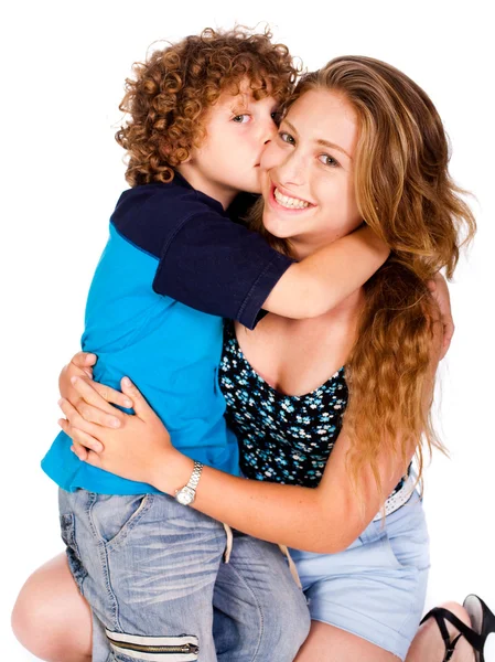 Mladý kluk líbat jeho maminka a při pohledu na fotoaparát — Stock fotografie