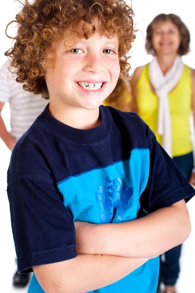 Young cute boy in focus with family in the background — Stok fotoğraf