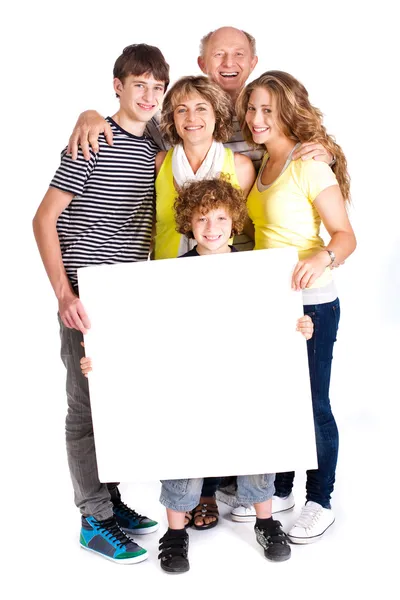 Retrato de una familia feliz sosteniendo un cartel — Foto de Stock