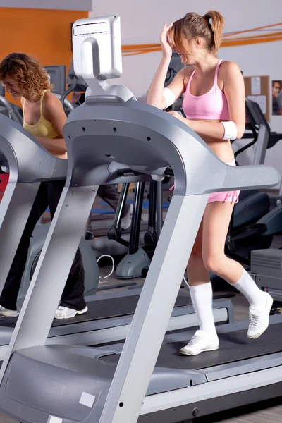 Vrouw op de lopende machine in de sportschool — Stockfoto