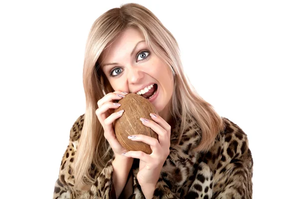 모피 코트를 입은 여자 gnaws 코코넛 — 스톡 사진