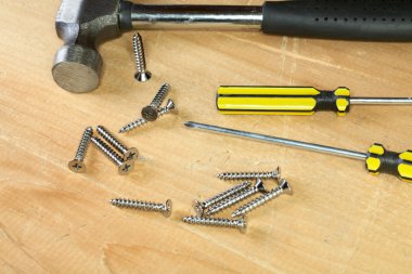 Hammer screw-driver screws on a board