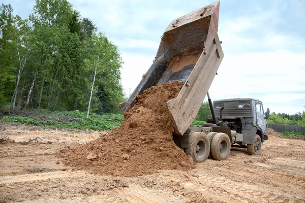 Dump-corpo caminhão descarrega um solo — Fotografia de Stock