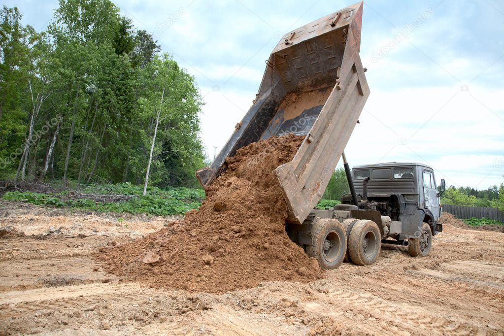 Dump-body truck unloads a ground