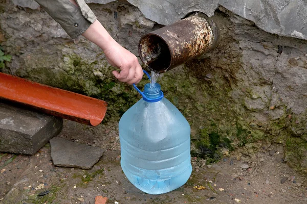De vrouwelijke hand houdt plastic fles met water — Stockfoto