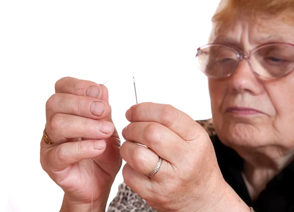 A velha mulher passa o fio na agulha — Fotografia de Stock