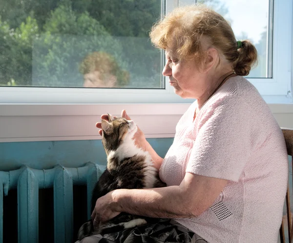 Die alte Frau streichelt die Katze — Stockfoto
