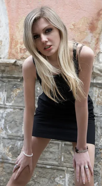 Het meisje de blonde in een zwarte jurk — Stockfoto
