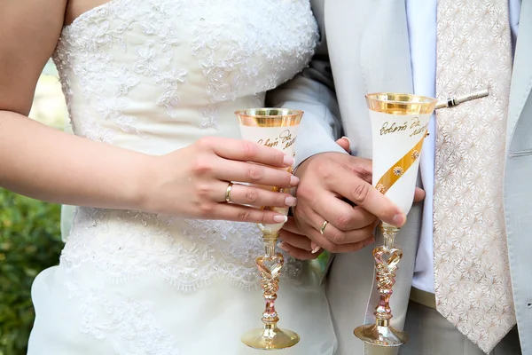 The groom and the bride hold glasses with sparkling — Stock Photo, Image