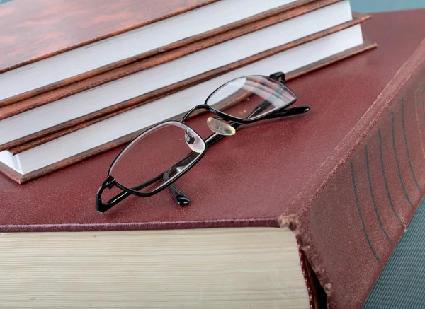 Pile of books and glasses on old volume — Stock Photo, Image