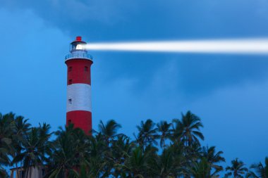 Lighthouse in night with light beam clipart