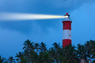 Lighthouse in night with light beam clipart