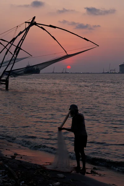 Pescador y redes de pesca chinas al atardecer. Kochi, Kerala, India — Foto de Stock