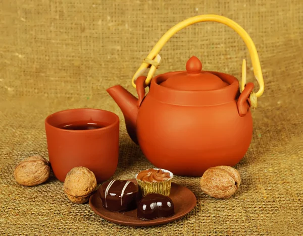 Clay teapot with sweets — Stock Photo, Image