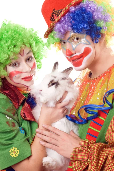 Due clown sorridenti con un coniglio bianco — Foto Stock
