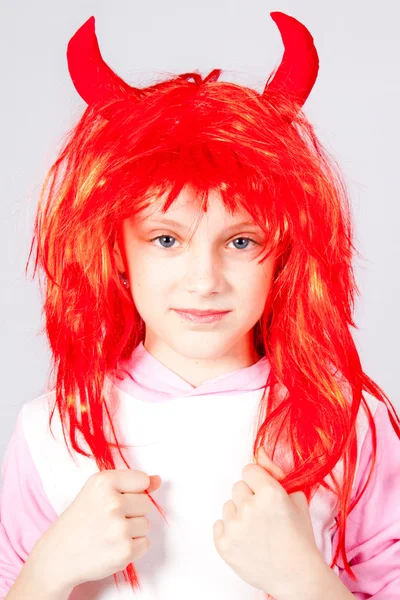 Mädchen in roter Perücke mit kleinen Hörnern — Stockfoto