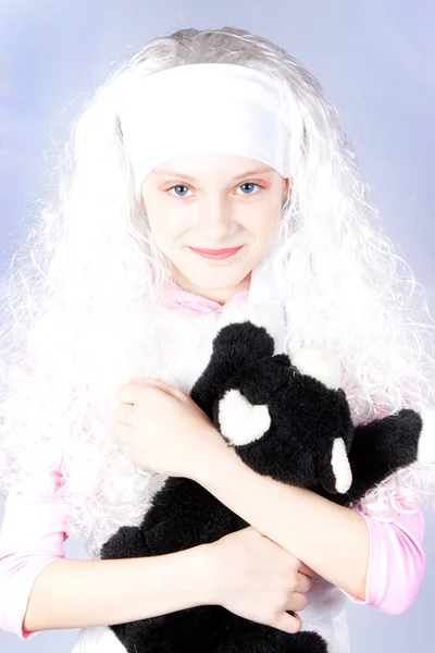 Menina em uma peruca com um brinquedo — Fotografia de Stock