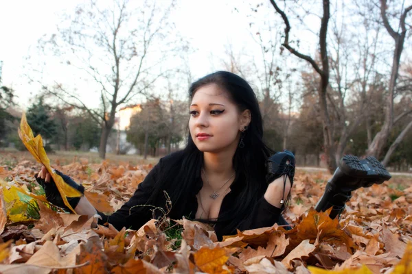 Girl sits on autumn leaves. — Stock Photo, Image
