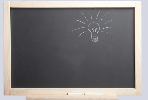 Stock image Light bulb on blackboard