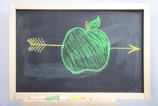 Яблоко и стрела на школьной доске — стоковое фото