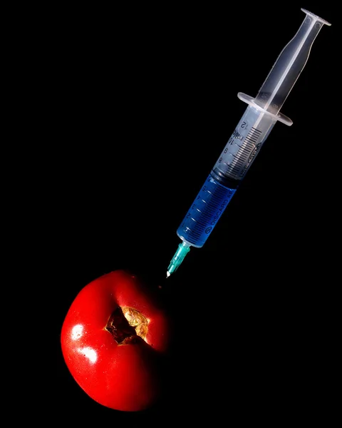Red tomatoes and a syringe — Stock Photo, Image